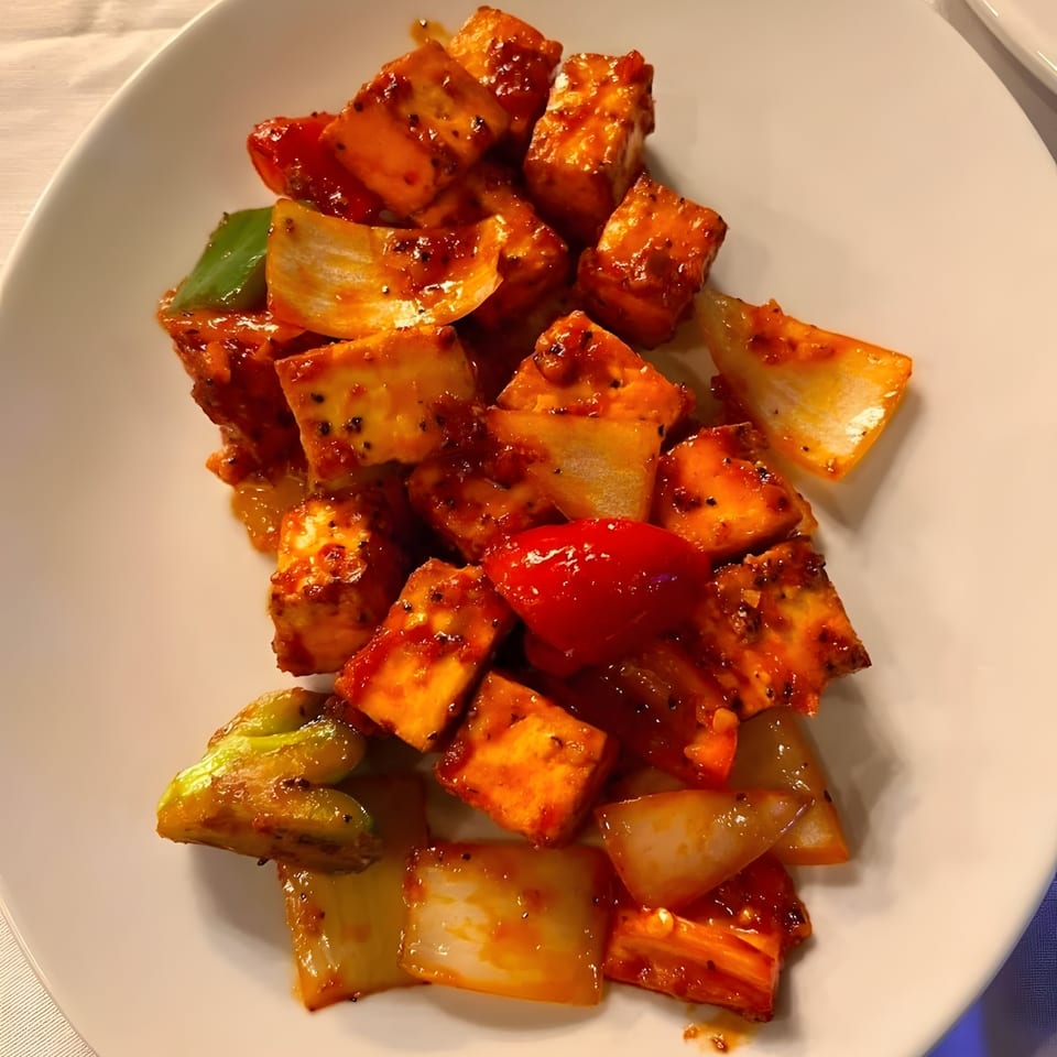 Royal India Palace's chili paneer, with paneer cubes, bell peppers, and onions in a spicy sauce.